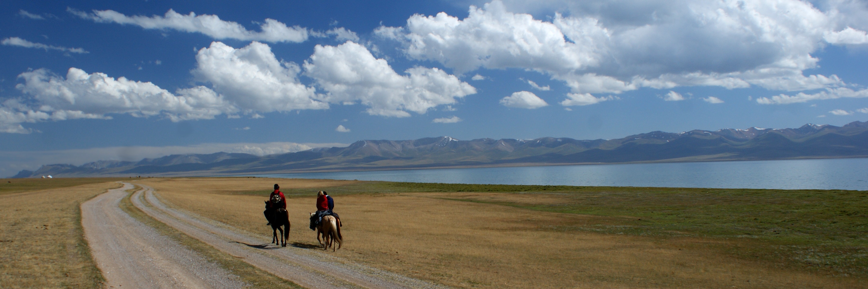 Horses and a yurt in a Kyrgyz mountain valley